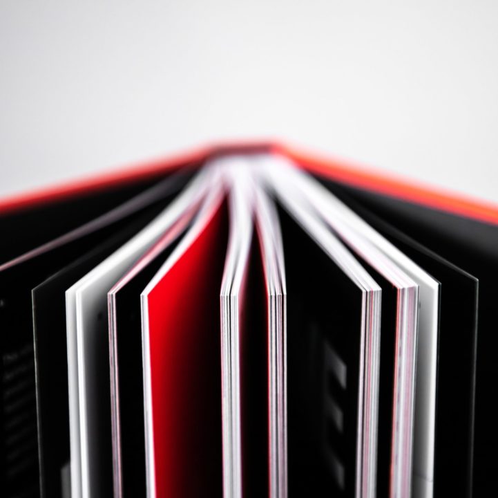 libro aperto con pagine nere, bianche e rosse sul visual design